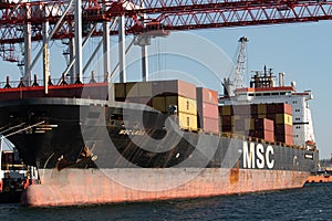 Odessa, Ukraine-202: Logistics terminal sends import-export cargo containers to cargo ship in seaport. Industrial landscape with