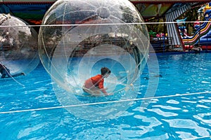 Odessa, Ukraine - May 6, 2019. Little children in an inflatable balloon, having fun on the water. The ball in the water -