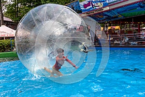 Odessa, Ukraine - May 6, 2019. Little children in an inflatable balloon, having fun on the water. The ball in the water -