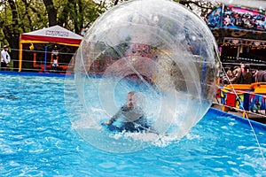 Odessa, Ukraine - May 6, 2019. Little children in an inflatable balloon, having fun on the water. The ball in the water -