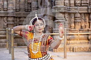 Odissi Dancer wears traditional costume posing at Konark sun temple, Odisha, India. Culture and traditions of India.