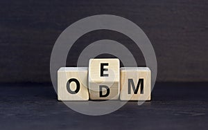 OEM or ODM symbol. Concept word OEM ODM original design equipment manufactirer on wooden block. Beautiful grey table grey