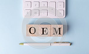 OEM on wooden cubes with pen and calculator, financial concept