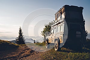 Off-road 4x4 with pop top elevating roof sleeping tent storage vehicle on the dirty country road in the Slovakian mountains in the