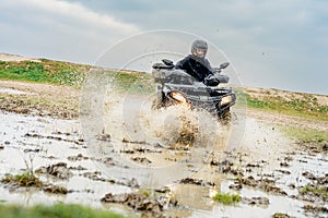 Off-road adventure with an ATV splashing through mud photo