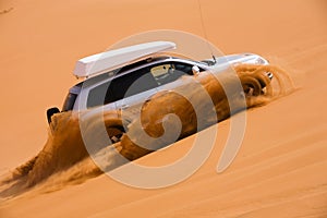 Off-road car going up the dune