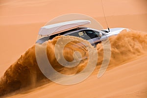 Off-road car going up the sand dune