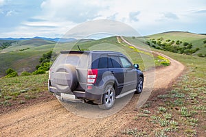 off-road car moves along a dirt mountain road