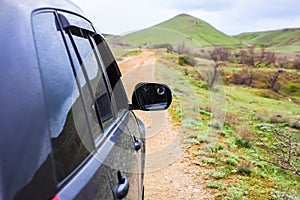 off-road car moves along a dirt mountain road