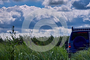 Off-road car is moving against the background of an incredibly beautiful sky