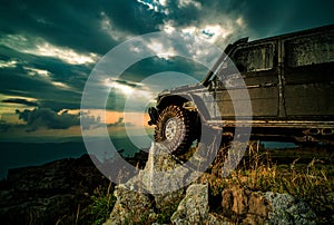 Off road car. Off-road Jeep car on bad gravel road. Wheel close up in a countryside landscape with a muddy road.