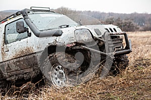 Off road car overcomning difficult pit on dirty road