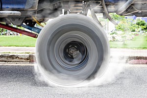 Off-road car spinning wheel burns rubber on floor