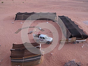 Off-road car among the tents of a Bedouin camp in the Wadi Rum desert, Jordan