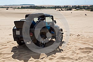 Off road car vehicle in white sand dune desert at Mui Ne