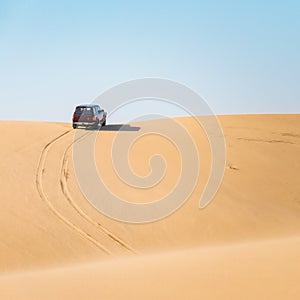 Off road desert adventure, car and tracks on sand.