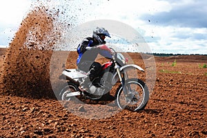 Off-road motorbike driving in dirt.