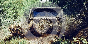 Off road sport truck between mountains landscape. Offroad vehicle coming out of a mud hole hazard. Drag racing car burns