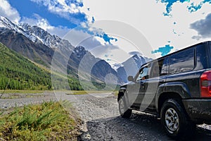 Off-road SUV car with Aktru mountain valley and glacier background. Adventure travel concept. Adventure tourism.