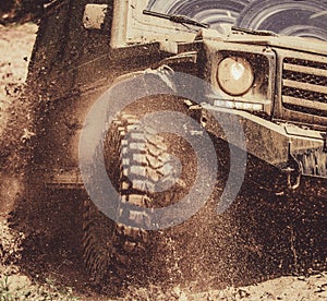 Off-road travel on mountain road. Travel concept with big 4x4 car. Mud and water splash in off-road racing. Motion and