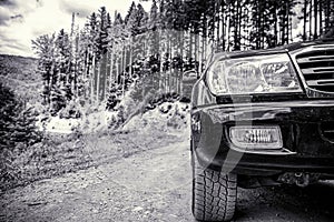 Off-road travel on mountain road. Travel concept with big car . Closeup photo of offroad wheel. Closeup of car wheel on