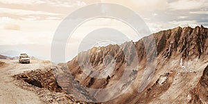 Off-road vehicle auto going through high altitude Mountain pass on Leh - Manali road in Northern Indian Himalaya, Ladakh region