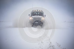 An off -road vehicle breaking through snowdrifts