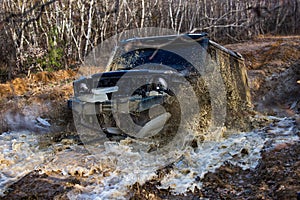 Off road vehicle coming out of a mud. Extreme entertainment concept. Offroad car in action. Rally racing. Car wheel