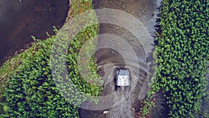 An off-road vehicle sails on the river. aerial above view top