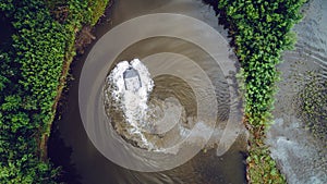 An off-road vehicle sails on the river. aerial above view top