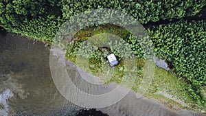 An off-road vehicle sails on the river. aerial above view top