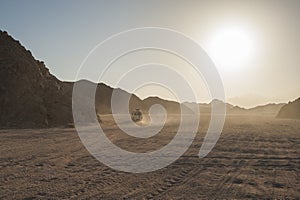 Off road vehicle traveling through arid desert landscape