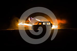 Off roader jeep silhouette on dark toned foggy sky background. Car with light at night