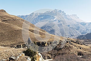 The off-season landscape of the mountains of the Caucasus on a sunny day. a man on the edge of a cliff looking out into