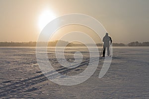 Off track cross-country skier on a windy frozen lake