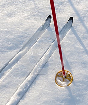 Off-track skis and ski pole on snow