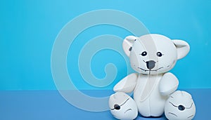 Offbeat teddy bear isolated on blue background with copy space