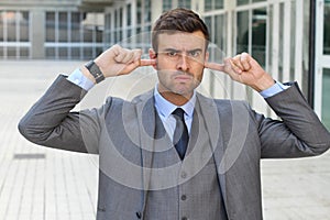 Offended businessman putting his fingers on the ears