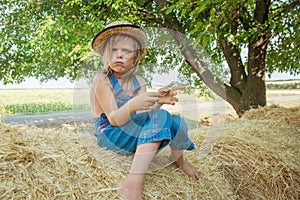 Offended child sits on a haystack
