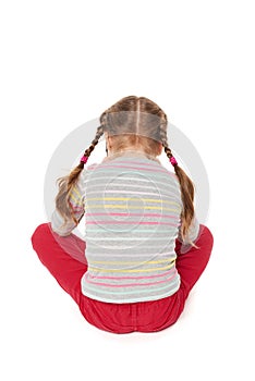 Offended child sitting on floor,back view