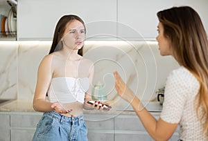 Offended daughter disputing with her mother in the kitchen