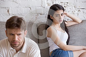 Offended frustrated girlfriend looking at sitting separately boy