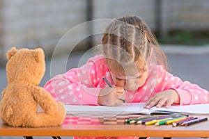 Offended girl draws a hunched figure in yard