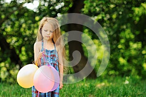 Offended little girl with baloons in a park