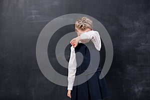 Offended schoolgirl stands at the blackboard