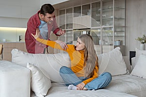 Offended upset woman wife pushes angry man husband away in heated home quarrel, family disagreement