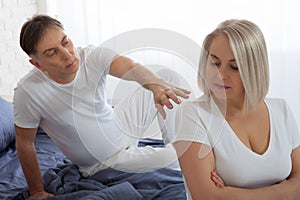 Offended woman and man trying to reconcile in bed