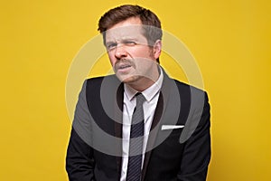 Offended young man in suit looking at camera with doubt and suspicion stressed with news