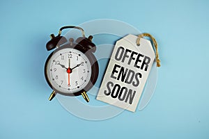 Offer Ends Soon text on price tag with alarm clock on blue background