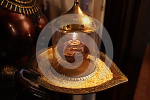 Offering of rice and a lit lamp on a deity